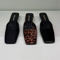 Three pairs of Prada square-toe mules in black satin, black patent leather, and leopard print calf hair.