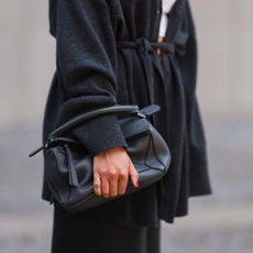 woman wearing a black coat and classic bag