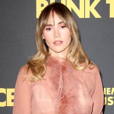 Suki Waterhouse wears a ruffled pink blouse