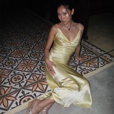 A woman wears a yellow cowl-neck rayon maxi dress and wedges.