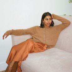 Monikh wears a brown cardigan and shiny maxi skirt