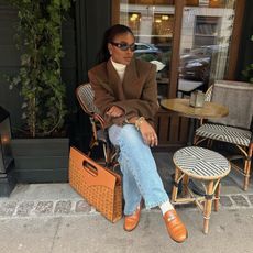 @nlmarilyn wearing rich mom style blazer, jeans and loafers sitting at Paris cafe